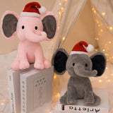 Two plush elephants, one pink and one gray, wearing Santa hats on books .
