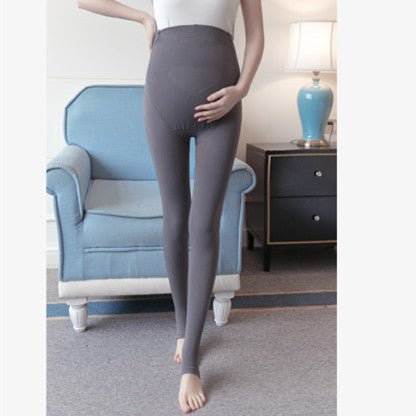 A person wearing gray leggings is standing in a room.