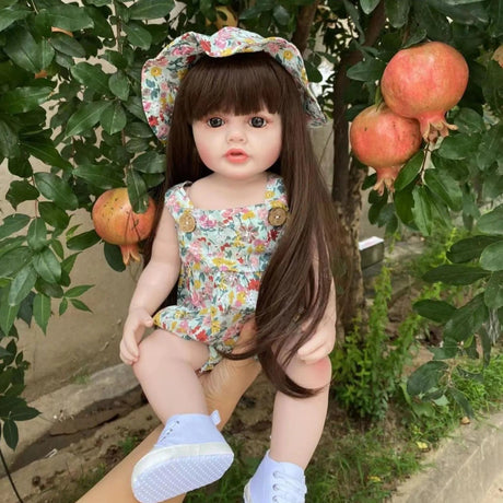 Doll in a floral outfit and hat among pomegranate trees