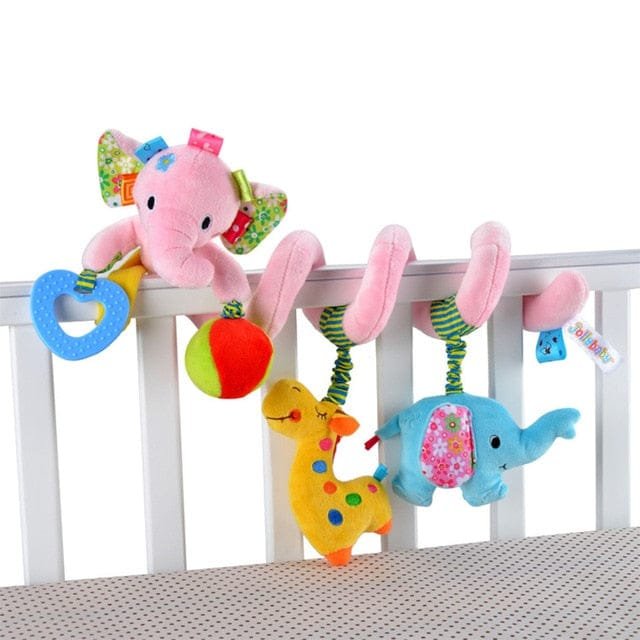 Colorful baby crib mobile with pink elephant, blue elephant, and yellow giraffe hanging from a white crib.
