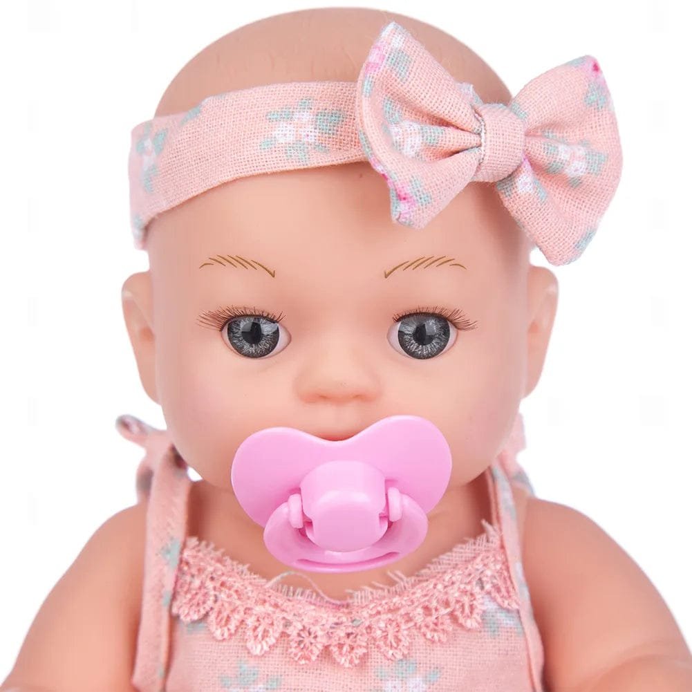Baby doll with pink outfit, headband, and pacifier.