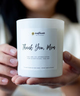 Candle with a 'Thank You, Mom' label held by a person