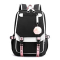 Black and white backpack with pink straps and a pom-pom charm.