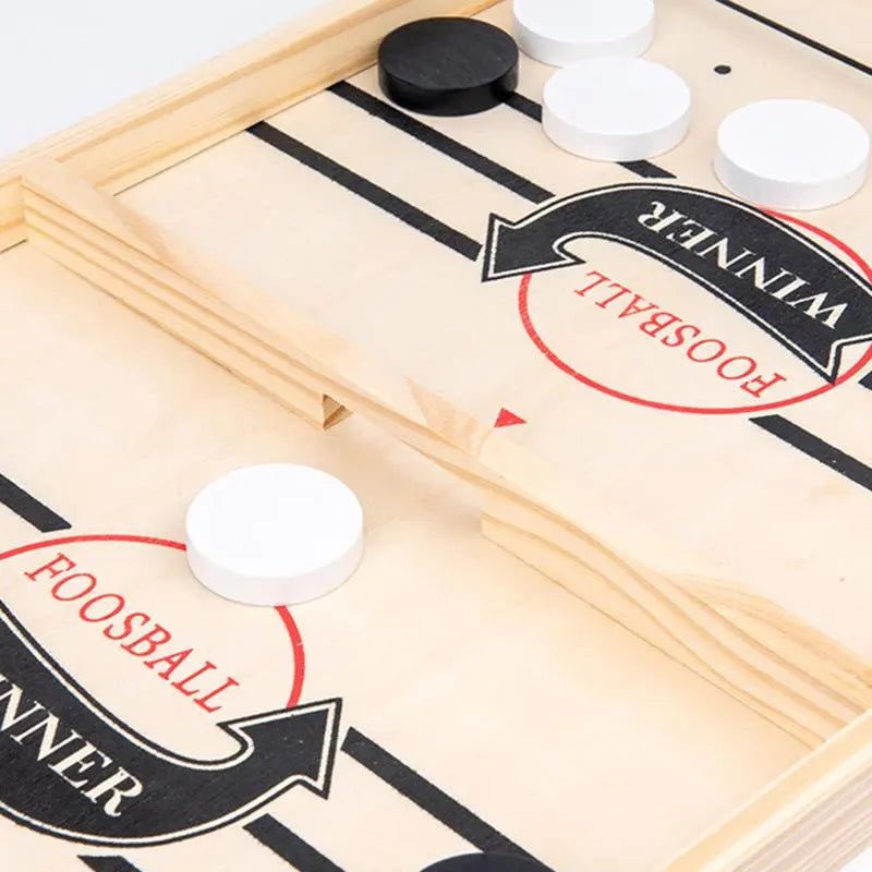 Close-up of a foosball table with white and black balls.