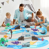 Man and two children playing with a marine-themed toy track set 