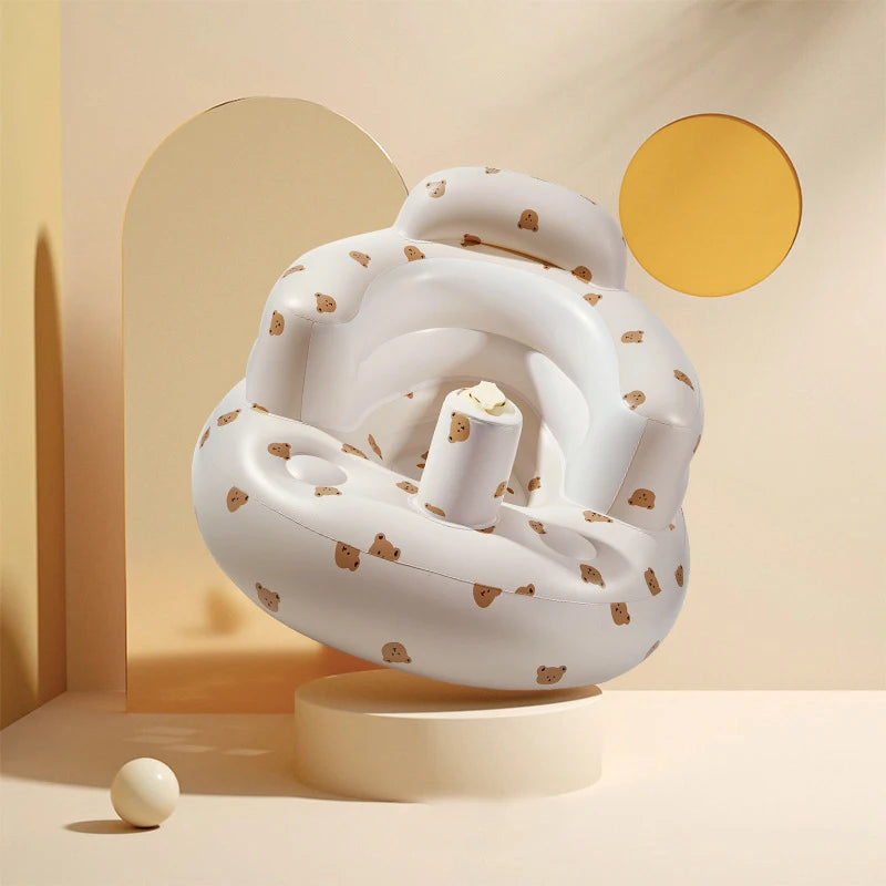 White baby seat with brown speckles on a beige platform against a beige wall with circular decorations.