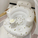 White inflatable baby seat with floral patterns on a white background
