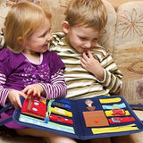 Two children interacting with a colorful felt book on a couch.