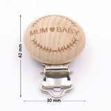 Wooden pacifier clip with 'MUM BABY' engraving and measurements on a white background