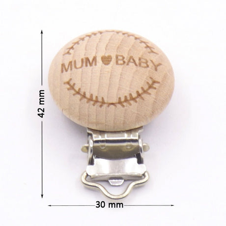 Wooden pacifier clip with 'MUM BABY' engraving and measurements on a white background