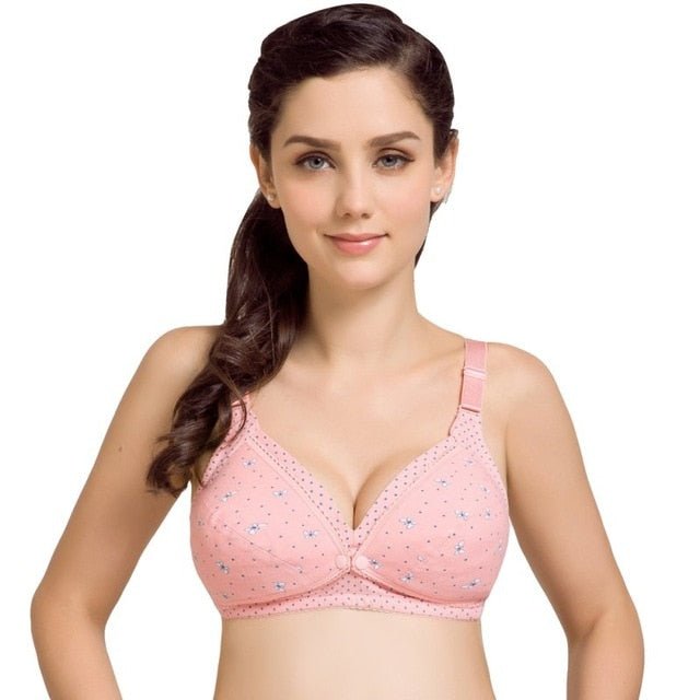 Woman wearing a pink bra with floral patterns on a white background