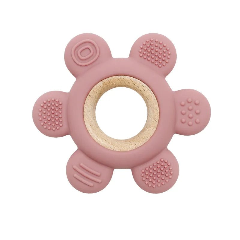 Pink silicone teething ring with wooden center on a white background