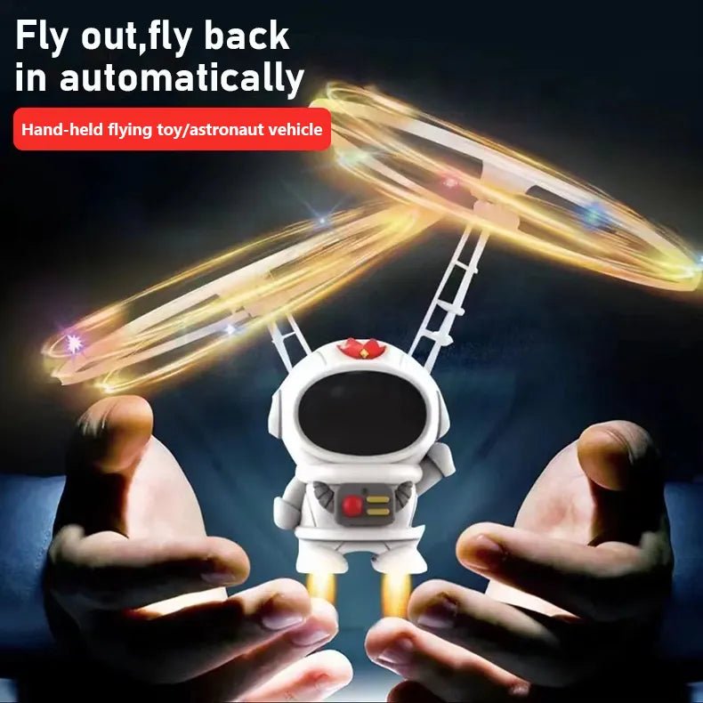Hand-held flying toy shaped like an astronaut vehicle with glowing effects, held between two hands against a dark background.