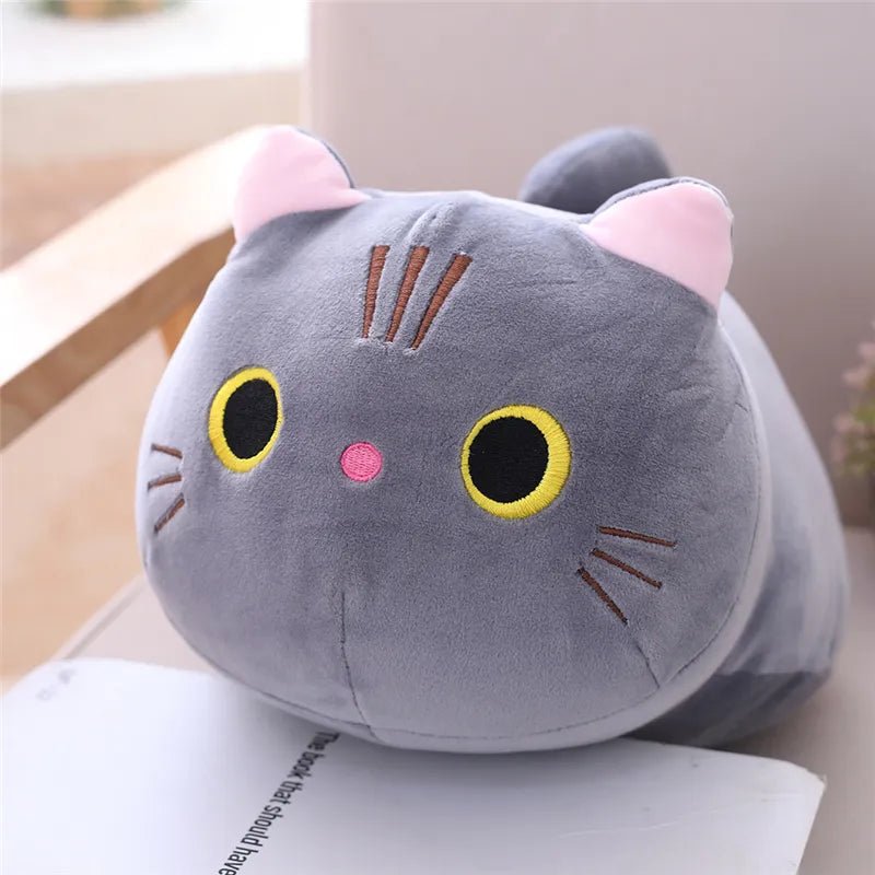Gray cat-shaped plush toy on a surface with a blurred background