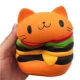 Plush toy shaped like a cat with a hamburger design held by a hand on a white background