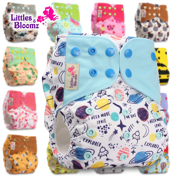 Colorful cloth diapers with space-themed design and visible brand 'Littles & Bloomz'.