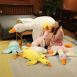Woman sitting on a bed surrounded by various plush ducks in a bedroom setting.