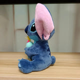 Blue plush toy with pink ears on a wooden surface