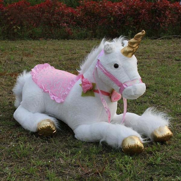 Plush unicorn toy with pink dress and gold hooves on grass
