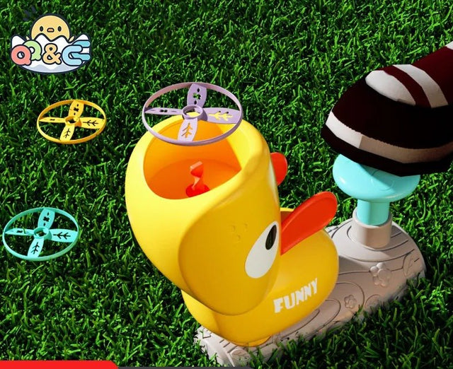 Toy duck with a propeller on grass, featuring the brand 'O&C'.