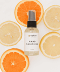 Hand sanitizer bottle with sunflower logo on a background of orange and lemon slices