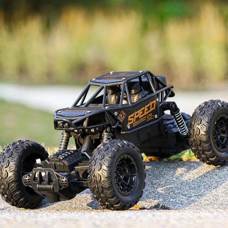 Toy off-road vehicle with large wheels on a gravel surface