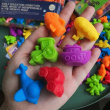 Colorful plastic toys shaped like animals are held in a hand.