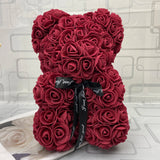 Red rose teddy bear with a black ribbon.