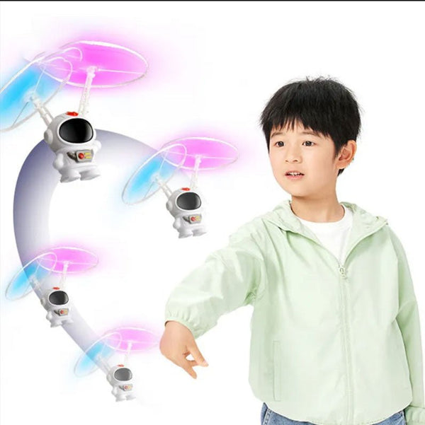Hand-controlled astronaut drone toy flown by a child outdoors for active backyard play.