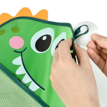 Demonstration of attaching a bath toy ball to the green dinosaur mesh storage bag.