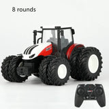 Toy tractor with large wheels and a remote control on a white background