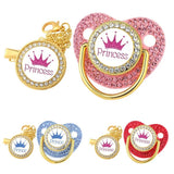 Decorative pacifiers with 'Prince' and 'Princess' text and crowns, in gold, pink, blue, and red.