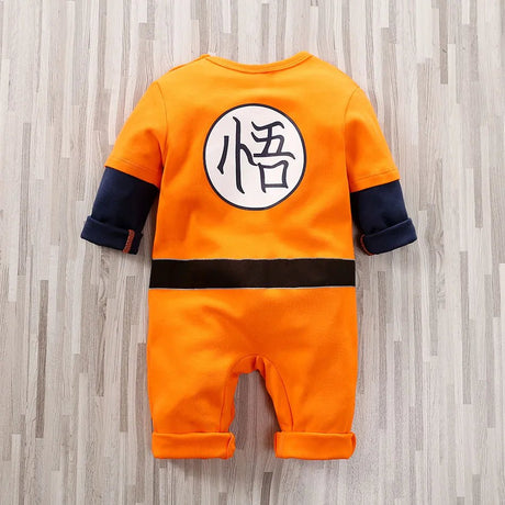 Orange baby onesie with a black-and-white symbol.