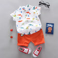 Children's outfit with a cartoon-patterned shirt, orange shorts, red sneakers, and a small bag.