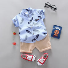 Children's outfit with blue shirt, beige shorts, red sneakers, and accessories 
