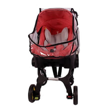 Baby carriage with clear plastic wind guard cover shielding red stroller from wind and rain.