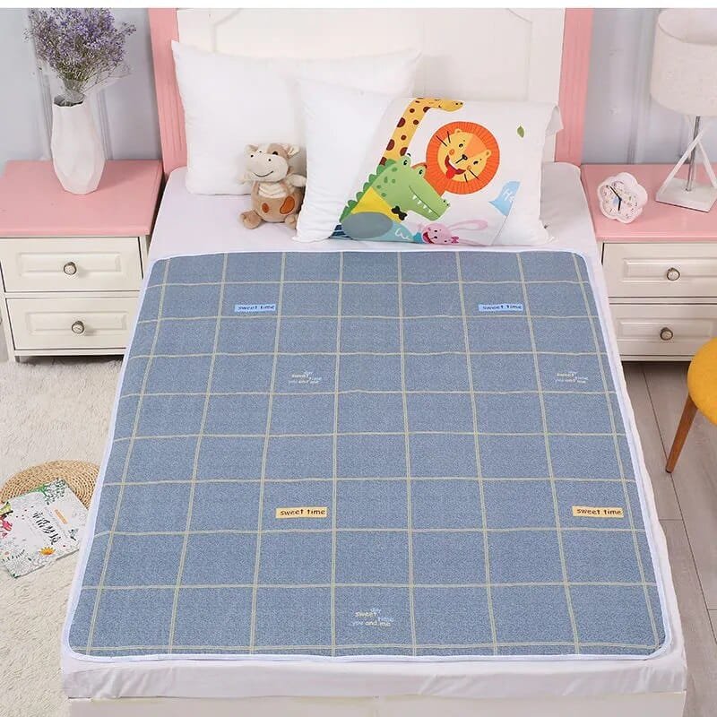 Blue checkered mattress cover on a bed with colorful pillows in a bedroom setting.