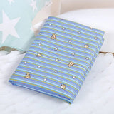 Folded blue and green striped fabric with teddy bear and star patterns