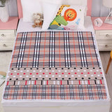 Plaid and polka dot blanket on a bed with cartoon animal pillow