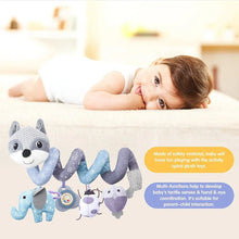 Baby lying on the bed with fox spiral plush toys featuring animal designs and music.