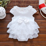 White lace baby dress on a wooden surface