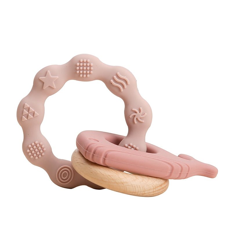 Pink silicone teething ring with wooden base.
