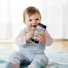 Baby holding a learning cellphone toy for musical lights and sounds pretend play at home.