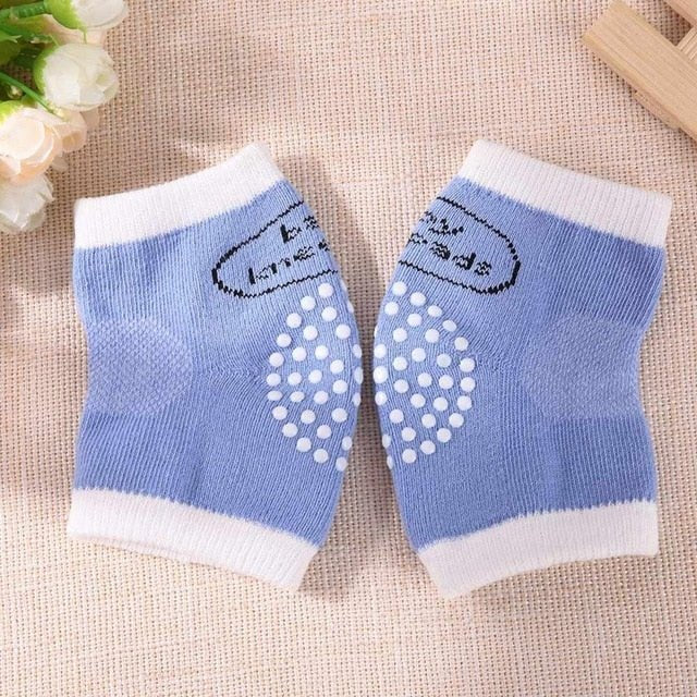Pair of blue knee pads with white accents on a textured surface.