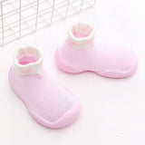 Pair of pink baby shoes with white soles