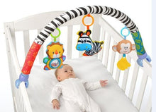 Baby lying in a crib with a colorful baby gym arch toy for newborn-friendly sensory play.