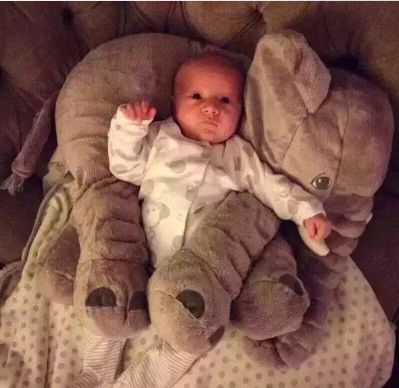 Baby lying on a large elephant plush pillow 60cm on the couch for relaxing playtime.