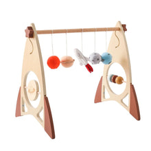 Wooden baby gym with hanging toys.