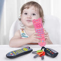 Child holding a pink toy remote control from the babys learning toy set for pretend play at home.