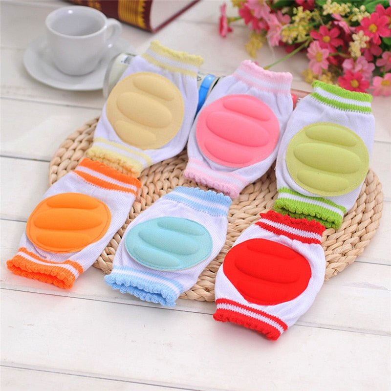 Colorful baby knee pads on a woven mat.